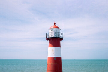 Red White Striped Lighthouse at the Seaside in Netherlands Sea Lake Water Blue