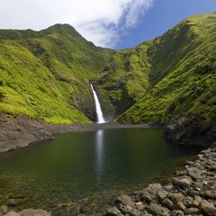 A cascading waterfall flows into a serene lake surrounded by lush green hills.