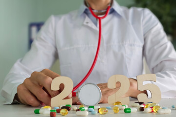 Doctor holding a stethoscope with 2025 and assorted colorful pills