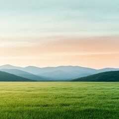 Obraz premium Tranquil field with a view of distant mountains under a colorful sky at sunset.