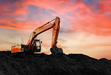 Excavator on sunset background. Open-pit mining. Backhoe dig ground in quarry. Heavy construction equipment on excavation on construction site. Excavator on groundwork on dramatic twilight. 