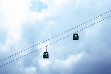 two ski lifts are suspended in the air one of which is a cable car