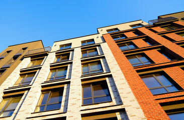 Modern facade building. Facade of high rise urban Modern house. balcony and Windows . Architecture building exterior, house block. High Rise house. Residential development in UK. City built. Blue sky. © MaxSafaniuk