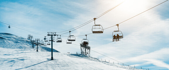 People on ski lift in winter sport resort - Travel and vacation concept - Focus on center cable car...