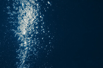 underwater splash bubbles in water environment, blue background with copy-space