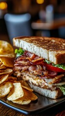 Delicious toasted bacon club sandwich with potato chips on plate