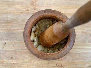 Wooden mortar and pestle with garlic