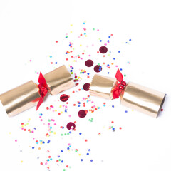 Isolated Christmas golden color pulled cracker and confetti, holiday festive cracker on white...