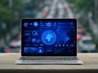Laptop computer with digital world map with data charts and stats screen on table over blur of rush hour with cars and road, Futuristic user interface technology online concept