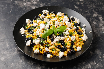 Blueberry Corn Feta Salad in white plate on wooden table. Healthy food concept