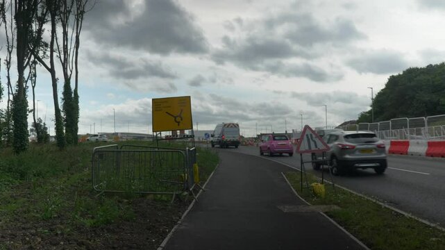 Roundabout with Barriers Cars Passing Road Cloudy Summers Day United Kingdom