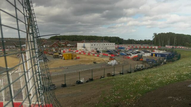 Meshed Fence With Construction Site and Road with Houses in Background