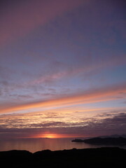 Sun setting over the Sea of the Hebrides, Scotland, with the Mull coast and Ardnamurchan silhouetted against the sunset