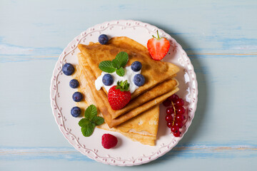 Crepes, thin pancakes  with yogurt and berries. Healthy food for breakfast. Top view