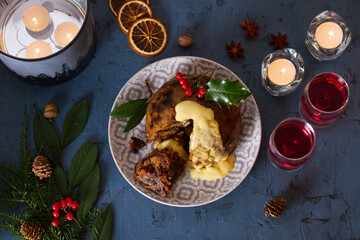 Fruit cake pudding with custard and Christmas decorations. Fruitcake ball, traditional dessert on Christmas. Top view