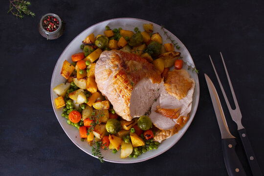 Roasted rolled and boned turkey breast fillet with potatoes, carrots, turnip and brussel sprouts. View from above