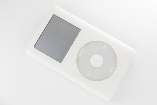 Milan, Italy - November 6, 2024: flat lay composition with an Apple iPod and AirPods headphones on white background.