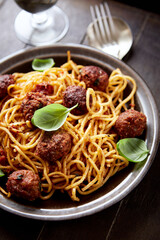 Spaghetti Pasta with Meatballs and fresh Basil on dark background.