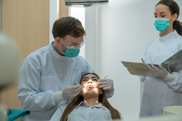 Dental team patient check up the teeth of patient in detall office.
