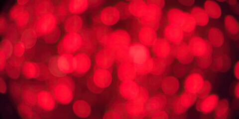 Blurry red bokeh snowflakes creating a festive and abstract background, winter