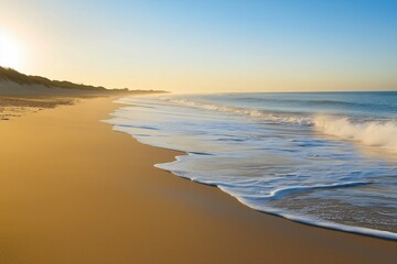 Fototapeta premium An untouched beach, caressed by gentle waves and crowned with a clear sky, inviting relaxation and contemplation.