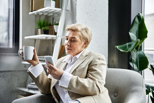 An elegant woman enjoys her coffee and checks her smartphone in a modern setting.