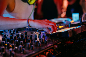 Close up view of a female dj with fresh nails mixing at a music festival