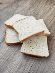 Square pieces of white toast bread on a wooden background