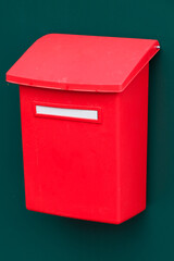 Red mailbox on a green wall