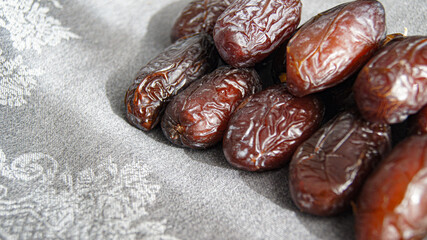 Dates, fruit dessert, healthy snack from dried fruits, beautiful ripe fruits of dates in abundance with spoon, on gray background, top view, Italy