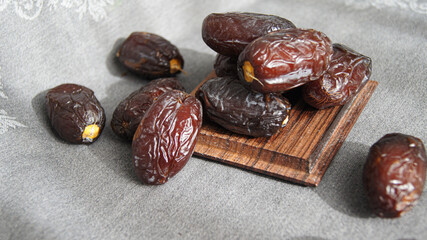 Dates, fruit dessert, healthy snack from dried fruits, beautiful ripe date fruits on wooden square...