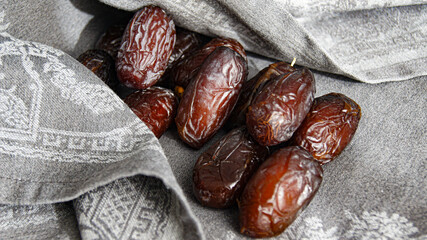 Dates, fruit dessert, healthy snack from dried fruits, beautiful ripe fruits of dates in abundance with spoon, on gray background, top view, Italy