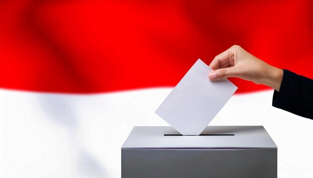 A woman's hand inserts a voting paper into a white voting box with Indonesia flag blurred background. Indonesia presidential election, Indonesia parliamentary election concept 