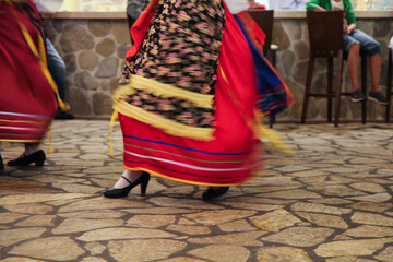 Cultural Dance Performance by Greek Women in Traditional Red and Blue Folk Dresses, Entertaining Guests at a Restaurant