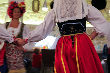 Cultural Dance Performance by Greek Women in Traditional Red and Blue Folk Dresses, Entertaining Guests at a Restaurant