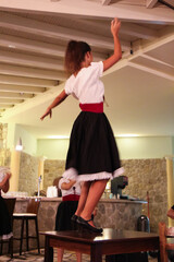 Greek Performer in Traditional Clothes Dancing on a Table: Entertainment at a Restaurant for Guests