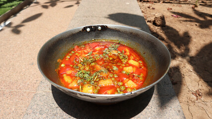 Tasty homemade Aloo mutter aur Tamatar ki sabji in gravy rassa cooked in indian kadai