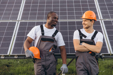 Smiling Engineers Collaborate in Front of Solar Panels