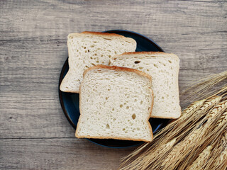 Square pieces of white toast bread and ears of dry wheat	