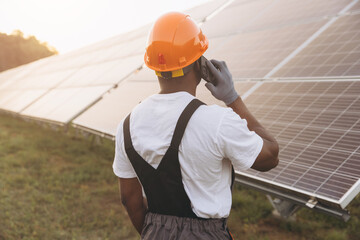 Engineer Inspecting Solar Panels While Making a Phone Call