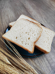 Square pieces of white toast bread and ears of dry wheat	