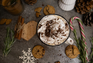 Mug with whipped cream, cocoa, chocolate cookies, cinnamon sticks, rosemary, Christmas candy