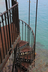Rustic Metal Gazebo with Rusty Spiral Stairs Leading Toward the Sea, Surrounded by Greek Island Landscape
