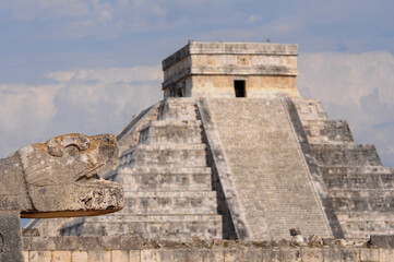 Fototapeta premium Chichen Itza ancient ruins with pyramid and carved serpent under blue sky