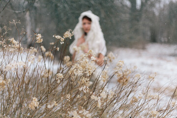 Woman in Snowy Field with Dried Flowers in Winter