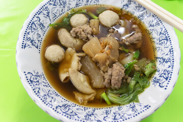 A delicious bowl of savory soup featuring various meats and vegetables, perfect for a hearty meal or culinary exploration.