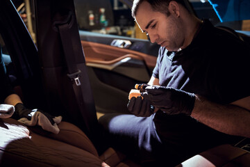 Male Technician Applying Product to Car Seat