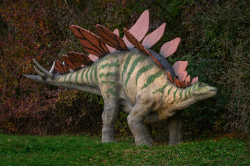 Large stegosaurus figurine by the forest.
