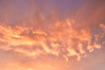 A beautiful sky tinted by the sun leaving vibrant shades of gold, pink, blue and multicolored. Clouds in the twilight evening and morning sky. Cloudy sky background in the evening, and during the day.