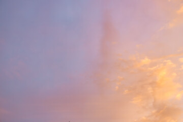 A beautiful sky tinted by the sun leaving vibrant shades of gold, pink, blue and multicolored. Clouds in the twilight evening and morning sky. Cloudy sky background in the evening, and during the day.